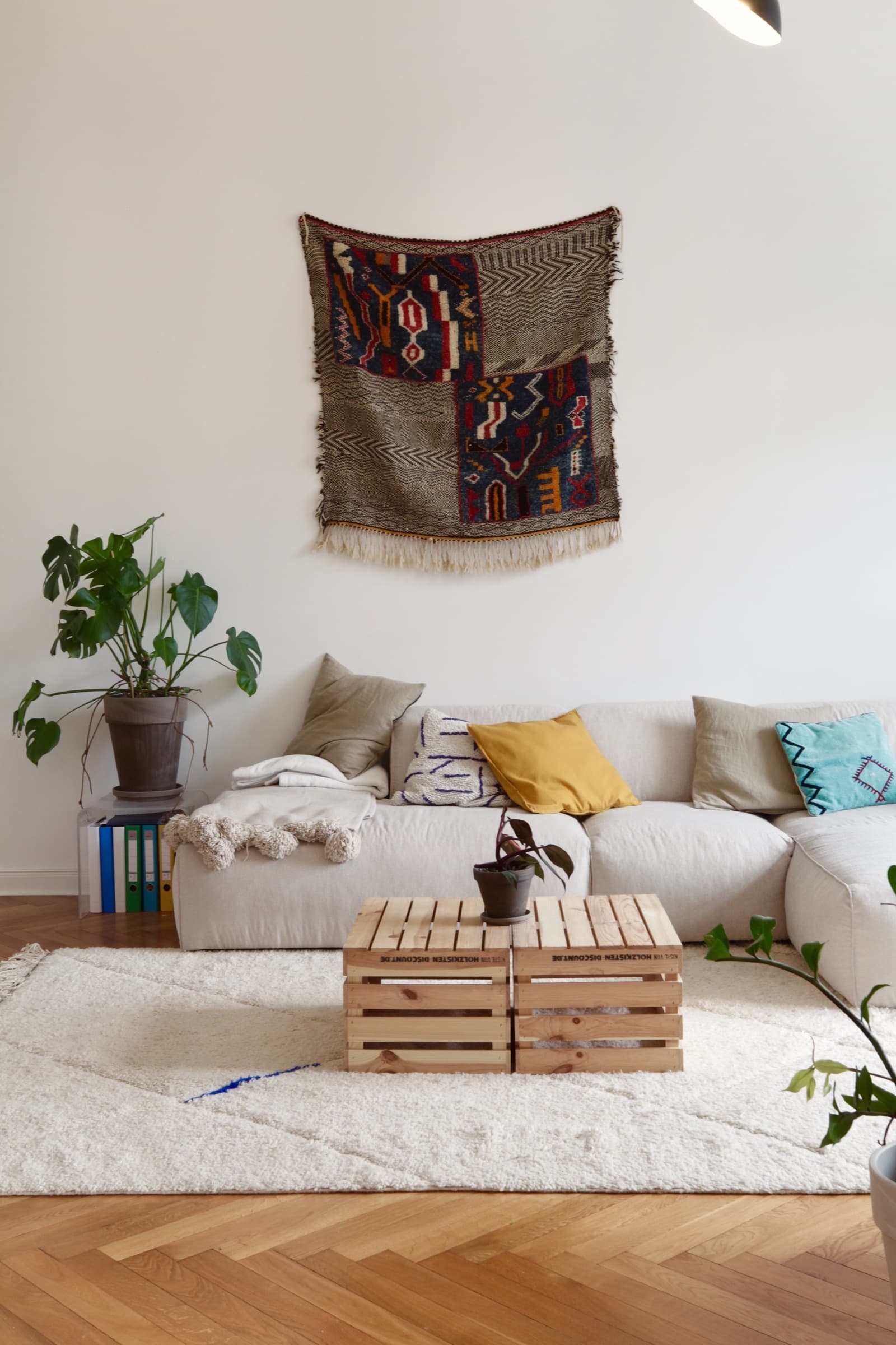 Kilim-Wandteppich über einem beigen Sofa mit farbigen Kissen